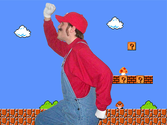 Kyle Orland, dressed as Mario, against a classic Nintendo background