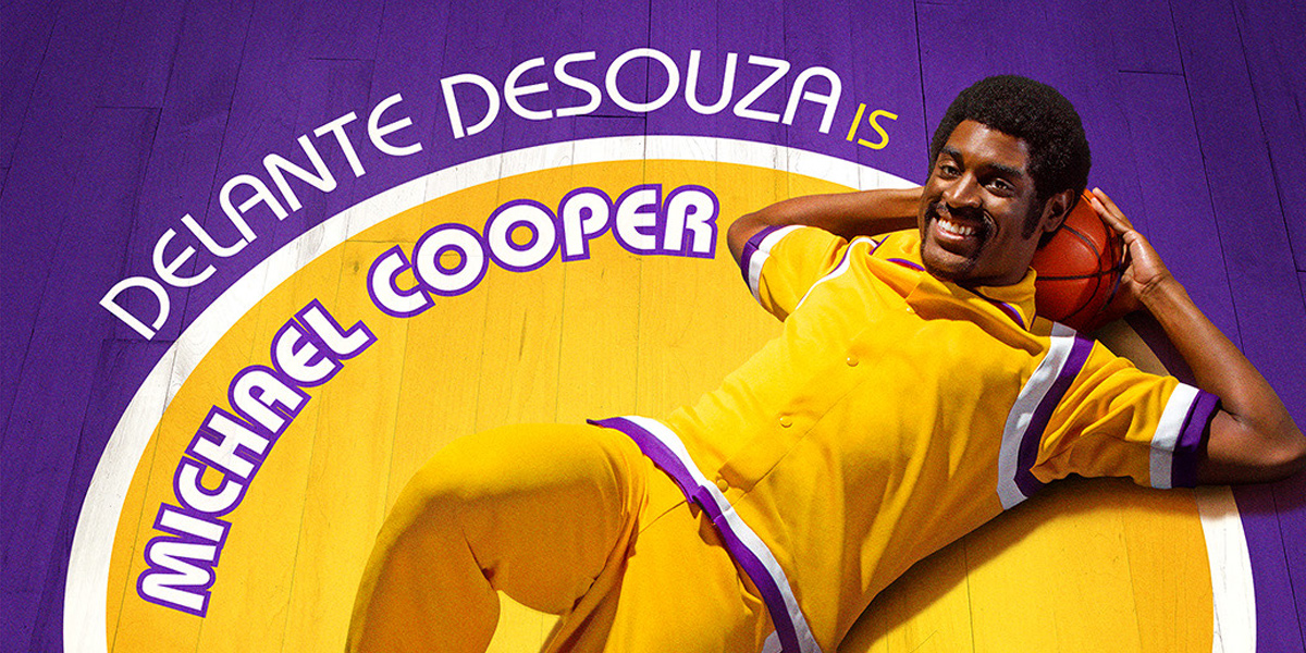 A promotional photo of Delante Desouza (B.S. 16) laying on a purple and gold basketball court, in costume as NBA shooting guard Michael Cooper for the HBO series Winning Time-The Rise of the Lakers
