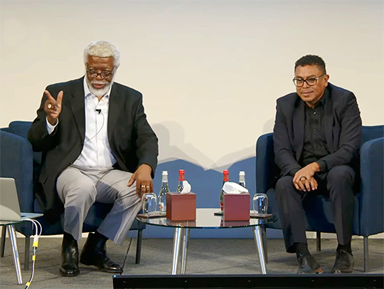 Professor Gates (L) onstage with an event host as he presents his lecture on the Islamic Tradition of the Art-Mathematics Connection and Quantum Gravity