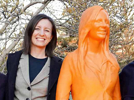 (L-R) Mercedes Taylor standing next to her orange statue likeness. Photo credit: Brett Lake at the U.S. Department of Energy.