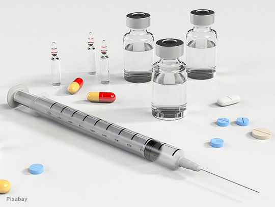 Photo of a syringe and various pills