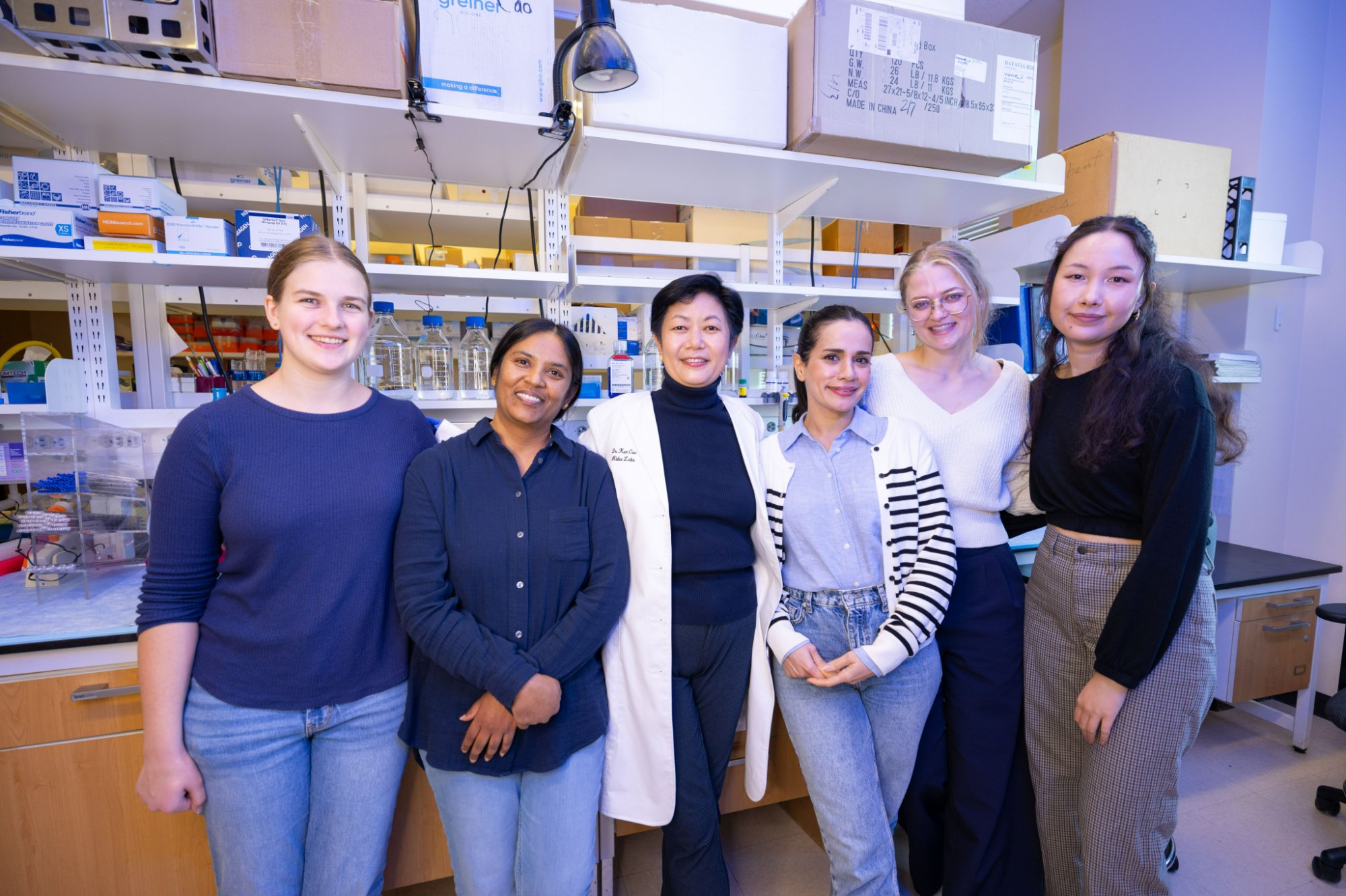 The Cao Lab team standing together in the lab