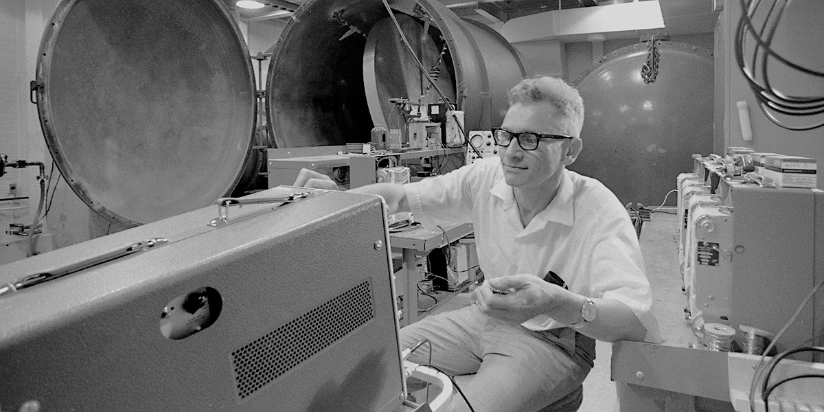 A black-and-white photo from 1971 showing Professor Joseph Weber sitting among the equipment in his lab. Credit: University of Maryland Archives.
