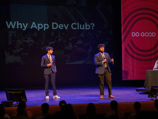Two members of the App Dev Club on stage at the Do Good Challenge. Credit: Dylan Singleton