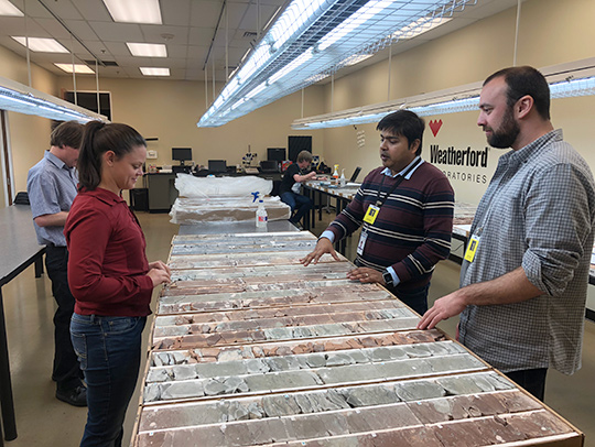 The research team, including Equinor's Swapan Sahoo (center right) and George Mason University's Geoff Gilleaudeau (right), investigates the rock samples taken from the Bakken Shale Formation. Photo courtesy of Alan Jay Kaufman.