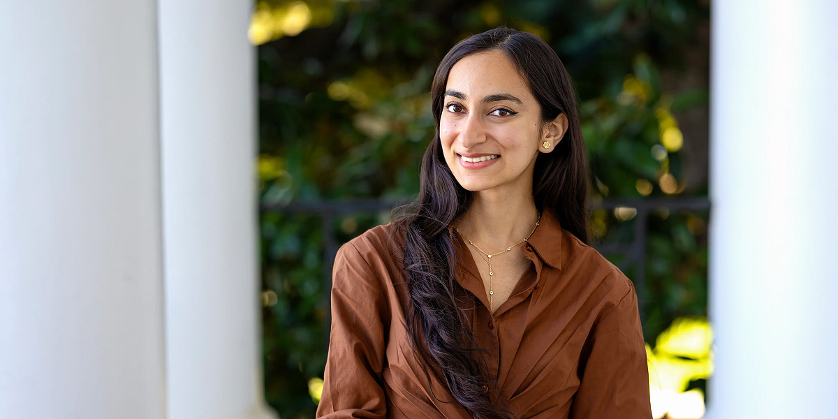 Portrait of Vainavi Gambhir on the porch of an academic building, standing among large white columns.