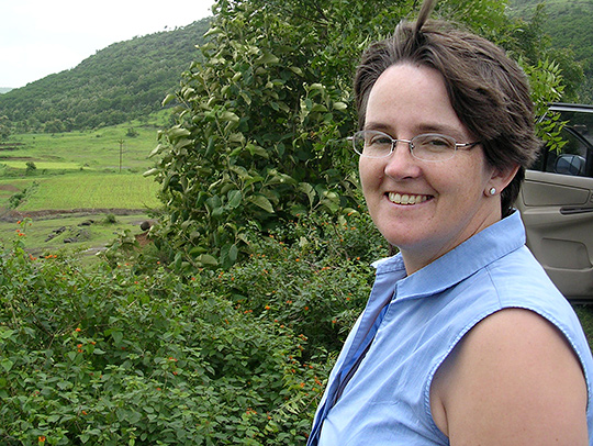 Brenda Dingus on the right side of the photo, looking out at a green, hilly landscape. Credit: Andrew Smith. Brenda Dingus on the right side of the photo, looking out at a green, hilly landscape. Credit: Andrew Smith.