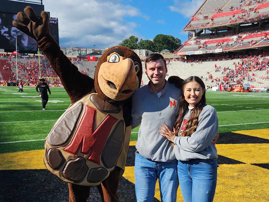 Hallie Pennington and Collin Vincent with Testudo, stanfing on the field at the University of Maryland's SECU Stadium. Photo courtesy of Collin Vincent.