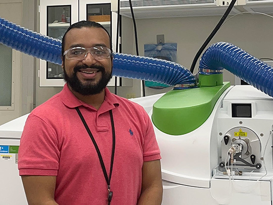 George Caceres in the lab, wearing eye protection