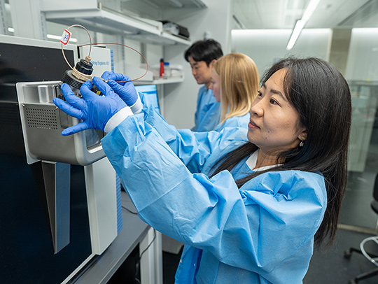 Lin Hao in her lab, loading a sample into a spectrometer. Credit: Mark Sherwood