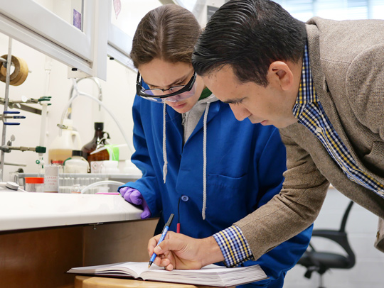 Osvaldo Gutierrez working with a student in the lab