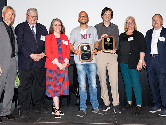 A group of standing people. Pratyush Tiwary is standing at center, holding a plaque. Credit: Mike Morgan