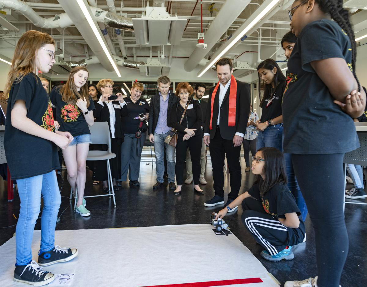 Students and guests in the Iribe Center working with a small robot. Students and guests in the Iribe Center working with a small robot.