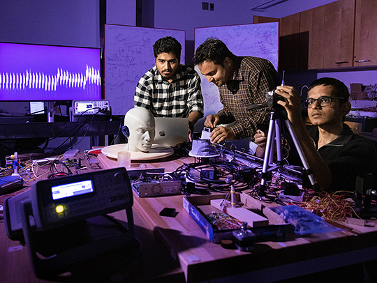 The Roy Group in the AI radio frequency lab, at a table full of equipment