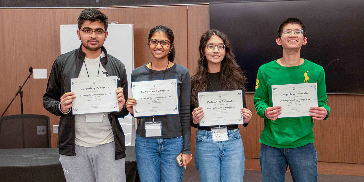 A row of 4 high school students, two boys and two girls, holding their award certificates.