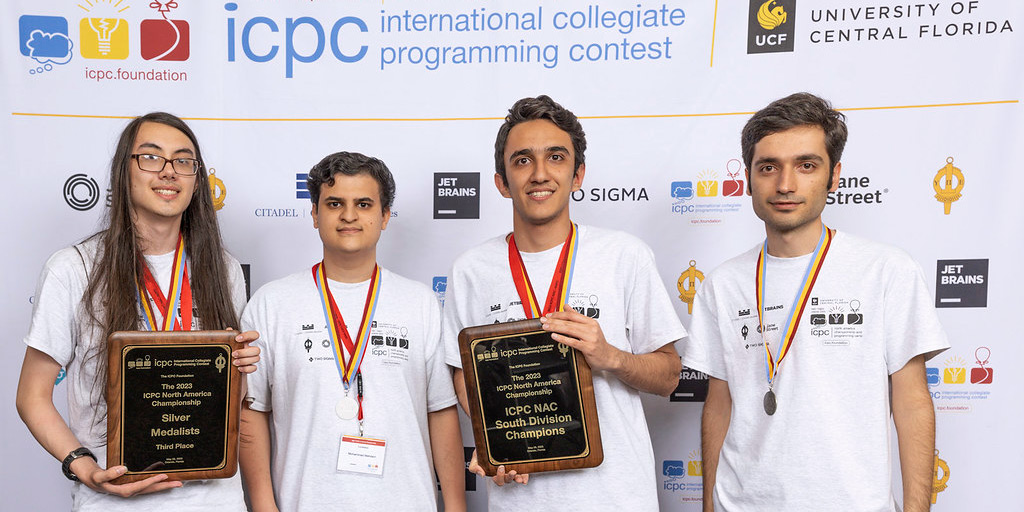 The UMD team at ICPC, wearing medals and holding plaques.