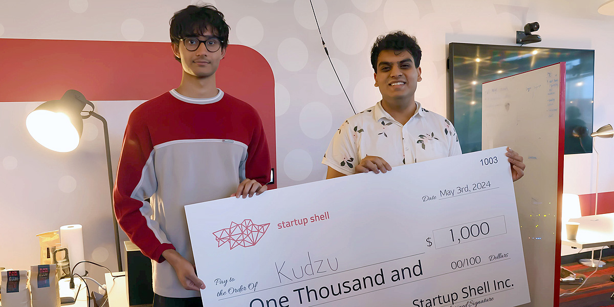 Founders of Kudzu holding a giant check.