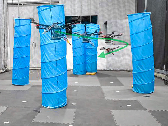 Drones maneuvering round column-like obstacles in an enclosed space.