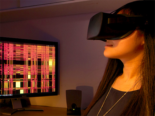 A young woman wearing a VR headset while sitting at a computer