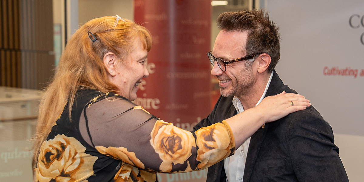 Jan Plane and Brendan Iribe hugging at a dedication event. Credit: Mark Sherwood.