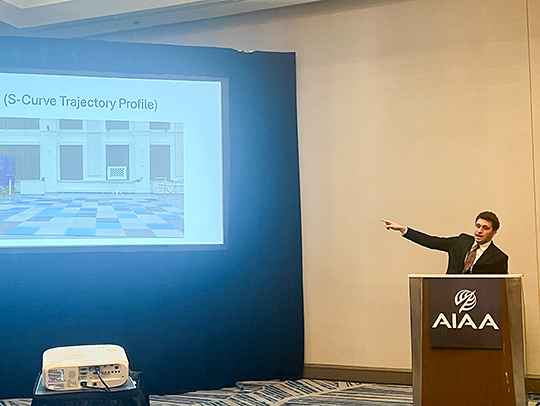 Kasra Torshizi gisturing to a large screen during a presentation about UMD's MATRIX Lab.
