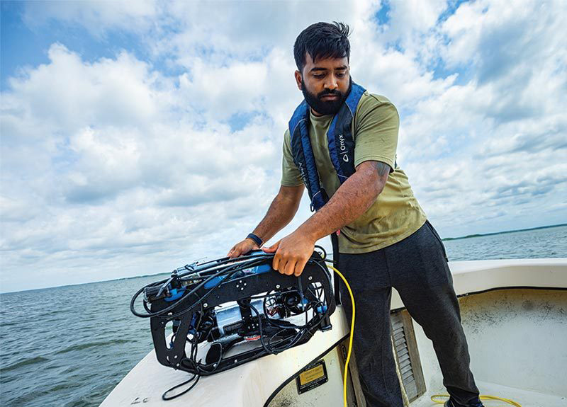 Keshav Rajasekaran Ph.D. '22 prepares to launch an underwater robot to seek oysters. Credit: Stephanie S. Cordle