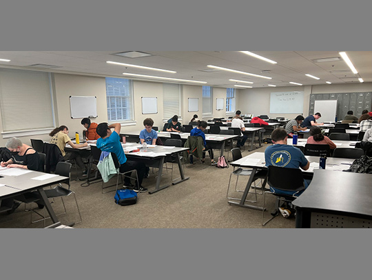 Students at the Putnam mathematics contest, working at desks.