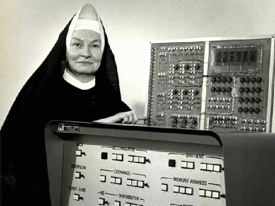 A black and white photo of a nun, Sister Mary K. Keller, also known as Sister Kenneth, with a Bi-Tran Six computer. Credit: Clarke University Archives.