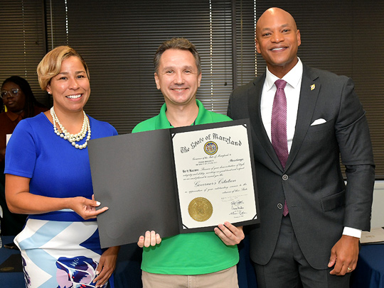 Todd Holden, center, holding a certificate declaring his Governor’s Citation for Outstanding Service.