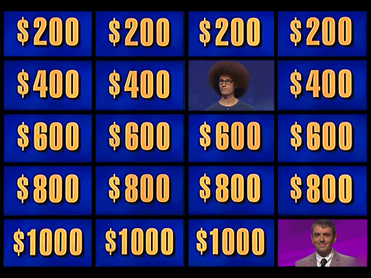 The multi-TV grid on the set of the game show Jeopardy, showing dollar values of the answers on most screen, and faces of two men in the others.