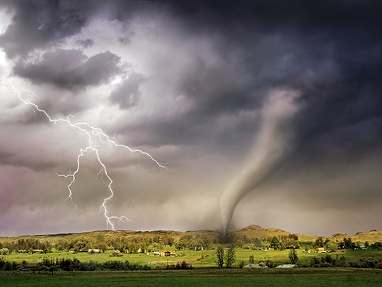 A composite photo of a stormy sky with lightning and a tornado