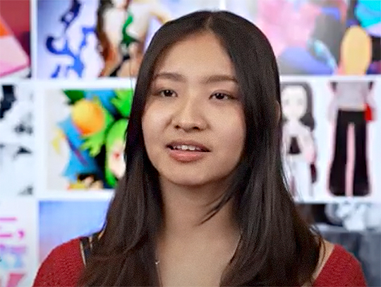 Danika Perez. A wall full of colorful art is behind her. Credit: Mark Sherwood.