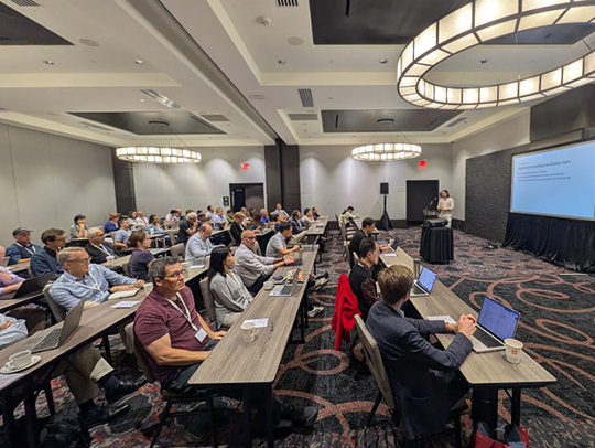 A group of people in a conference room watching a presentation