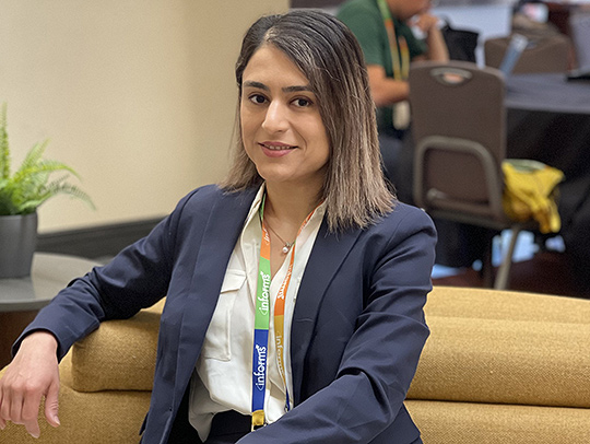 Parvin Mohammadiarvejeh, sitting on a couch and wearing a suit.