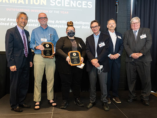 A group photo of the Geology-led team that won Invention of the Year-Information Sciences holding plaque-style awards. Credit: Mike Morgan