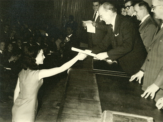 A yellowed black and white photo of Eugenia receiving her bachelor's degree in 1965
