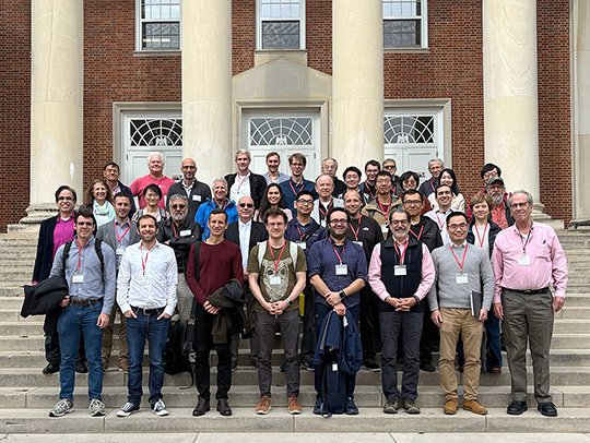 A group photo of people celebrating Reza Malek-Madani's retirement, on the steps of Kirwan Hall.