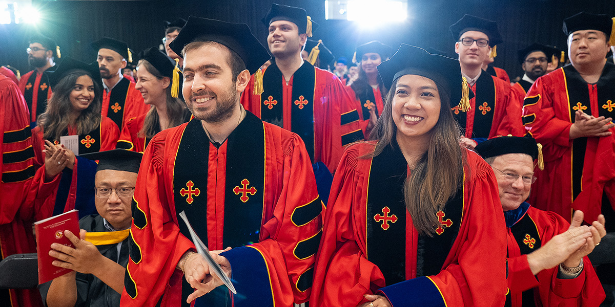 A crowd of freshly-hooded Ph.D. students in graduation regalia celebrading at the conclusion of their graduation ceremony. Credit: Mark Sherwood.