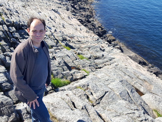Laurent Montési on an outcrop of rocks from Earth's lower crust, now exposed in the Lofoten Islands, Norway. Image courtesy of Wenlu Zhu.