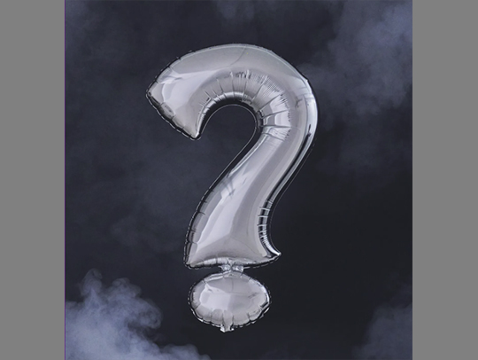A mylar baloon in the shape of a question mark against a dark, cloudy sky. Credit: New York Times.