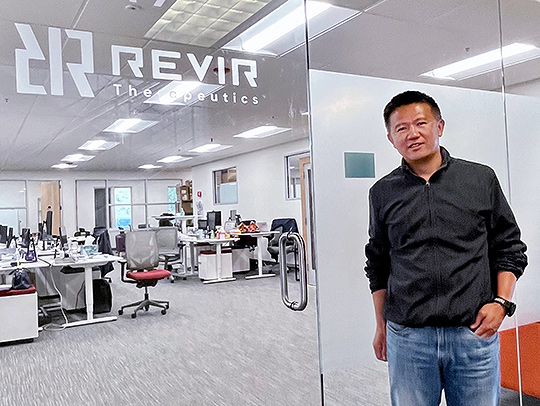 Peng Yue standing outside the glass office walls of ReviR Therapeutics. Peng Yue standing outside the glass office walls of ReviR Therapeutics.