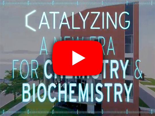 A video still with a play button, showing the opening of a video about the new chemistry wing.