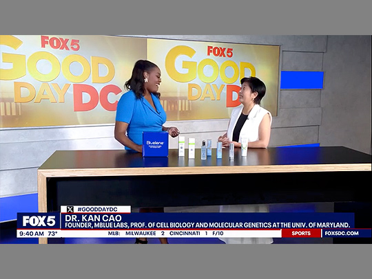 A Kan Cao laughing with a host on Fox5's Good Day DC show.